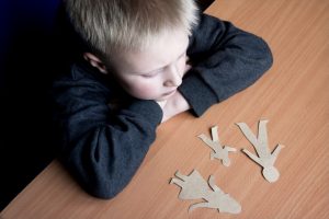 Child looking at cutouts of a family