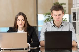 angry businesspeople using computers disputing at workplace