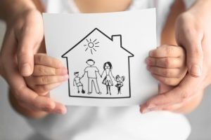 a kid holding a drawing of a family in a home